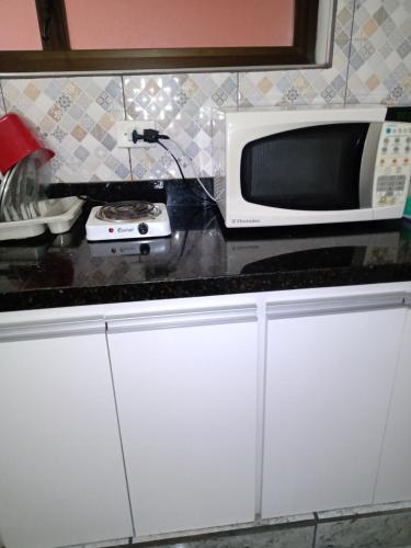 a microwave sitting on top of a kitchen counter at Suíte no Morumbi in Sao Paulo