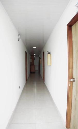 an empty hallway with a white wall and a door at sea crab in San Andrés