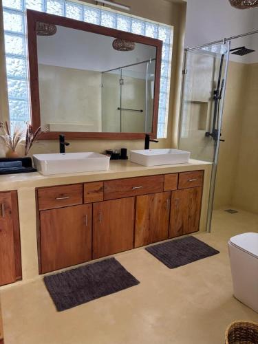 a bathroom with two sinks and a large mirror at Interlanka Coast Living in Ahangama
