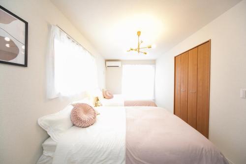 a bedroom with a white bed and a window at Nagashima Riverside Resort 5 in Kuwana