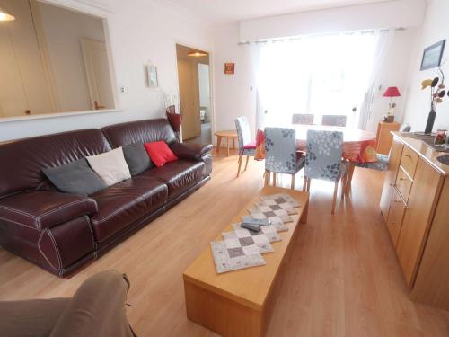 un salon avec un canapé en cuir marron et une table dans l'établissement Appartement T2 à Bénodet proche plages, vue rivière - FR-1-481-178, à Bénodet