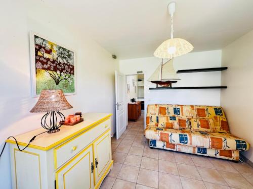 une chambre avec un lit et une table avec une lampe dans l'établissement Maison à Fouras pour 2-3 pers avec grand jardin - FR-1-709-99, à Fouras