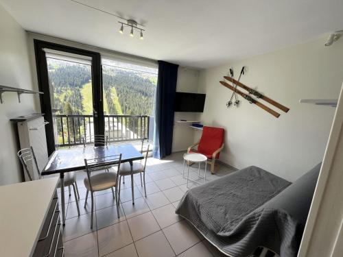 Cette chambre dispose d'une table, de chaises et d'un balcon. dans l'établissement Studio rénové proche pistes et commerces avec balcon pour 4 personnes - FR-1-425-234, à Arâches-la-Frasse