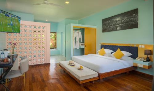 a bedroom with a large white bed and a television at Sala Siem Reap Resort in Siem Reap