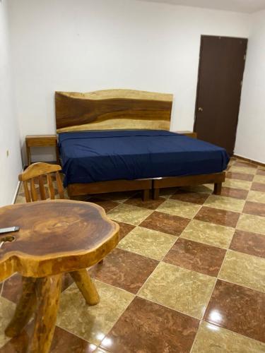 a bedroom with a bed and a table and a stool at Colibrí Apartment in Valladolid