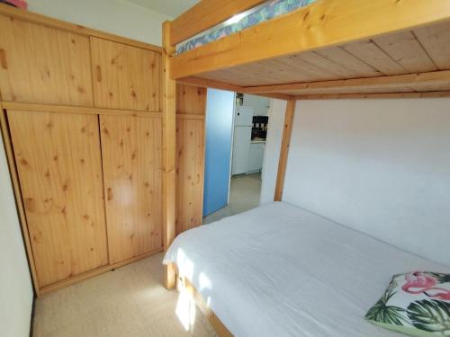 - une chambre avec des lits superposés et des murs en bois dans l'établissement Appartement T3 proche plage et commerces - 6 personnes - Narbonne-Plage - FR-1-795-66, à Narbonne