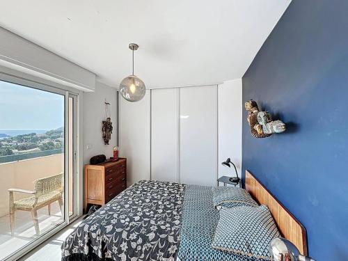 une chambre avec un lit et un mur bleu dans l'établissement Appartement T4 avec vue mer à La Ciotat, wifi et parking inclus - FR-1-770-52, à La Ciotat