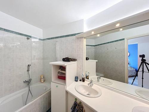 une salle de bain avec un lavabo, une baignoire et un miroir dans l'établissement Appartement T4 avec vue mer à La Ciotat, wifi et parking inclus - FR-1-770-52, à La Ciotat