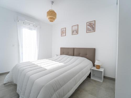 une chambre blanche avec un grand lit blanc et une fenêtre dans l'établissement Mimizan Plage - T2 équipé à 400m océan, parking, 4 pers. - FR-1-50-178, à Mimizan