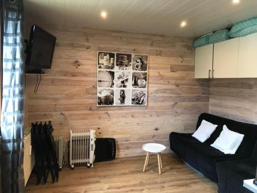 - un salon avec un mur en bois dans l'établissement Studio rénové à Pra-Loup pour 4 pers. proche station - FR-1-165A-199, à Uvernet