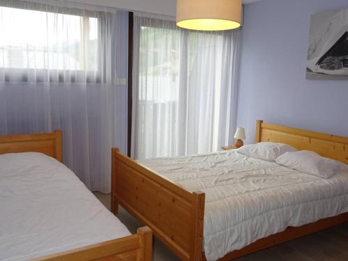une chambre avec deux lits et une fenêtre dans l'établissement Appartement 3 pièces - 7 pers - Confort - Parking - Les Gets - FR-1-802-96, aux Gets