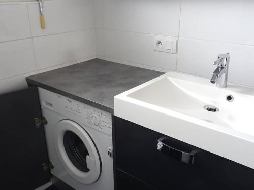 une salle de bain avec un lavabo et une machine à laver dans l'établissement Appartement 3 pièces - 7 pers - Confort - Parking - Les Gets - FR-1-802-96, aux Gets