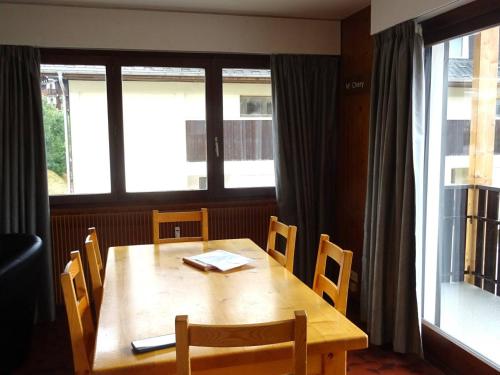 - une table et des chaises en bois dans une chambre avec fenêtre dans l'établissement Appartement 3 pièces - 7 pers - Confort - Parking - Les Gets - FR-1-802-96, aux Gets