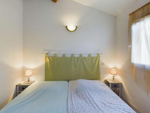 une chambre avec un grand lit avec deux tables de nuit dans l'établissement Maison mitoyenne 5 pers, chambres climatisées, parking, animaux, wifi inclus - FR-1-326-859, à Marseillan