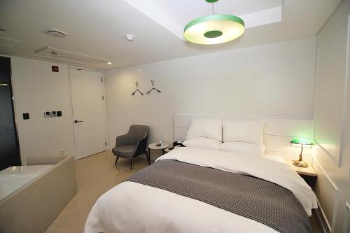 a bedroom with a bed and a bathroom with a tub at Hapjeong Circle Hotel in Seoul