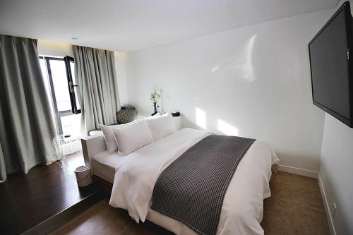 a bedroom with a large bed and a flat screen tv at Hapjeong Circle Hotel in Seoul