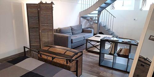 un salon avec un canapé et un escalier dans l'établissement L'antre, à Rouen