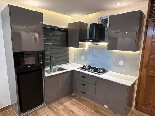 a kitchen with a black refrigerator and a sink at Bhurban Suites in Bhurban