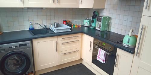 une cuisine avec un évier et une machine à laver dans l'établissement L'antre, à Rouen