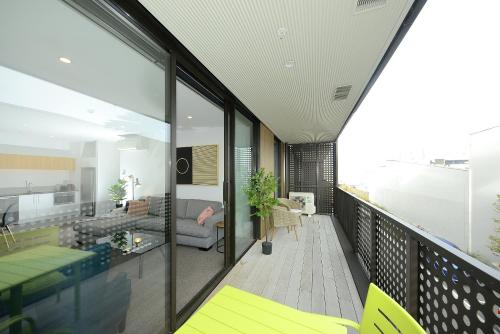 a balcony with a view of a living room at Relax and Unwind - Central City Hideaway with Carpark in Christchurch