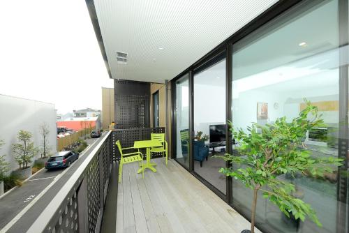an apartment balcony with a table and a desk at Relax and Unwind - Central City Hideaway with Carpark in Christchurch
