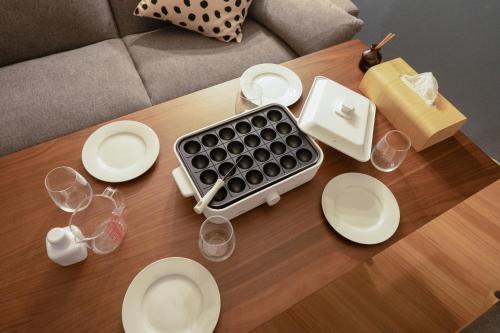 a table with white plates and a keyboard on it at AsashiobashiBase in Osaka