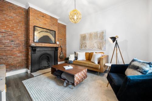 ein Wohnzimmer mit Couch und Kamin in der Unterkunft The Velvet Cottage in Adelaide