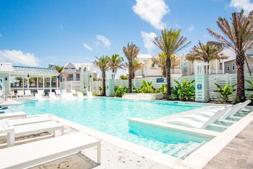 a swimming pool with chaise lounge chairs and palm trees at Keepin' It Reel 234 LAK in Port Aransas