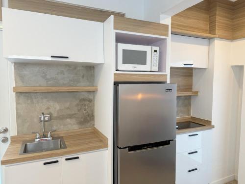 a kitchen with a stainless steel refrigerator and a microwave at New! Cozy Cool Studio Near Beach! in San Juan