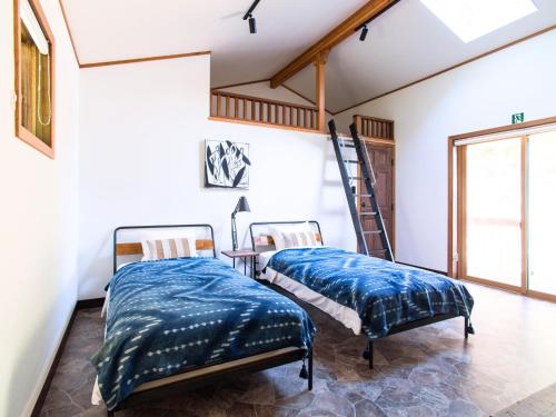 two beds in a room with a ladder at Monterey House by SANA in Tateyama