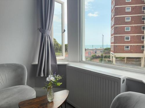 a living room with a chair and a window at Inn By The Sea, Portsmouth - EN SUITE Rooms with Sea View Possible, parking EV 22kW in Portsmouth