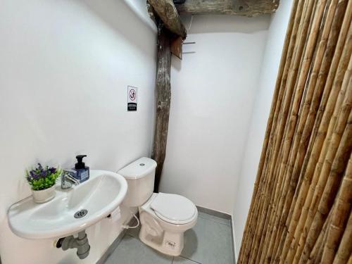 a bathroom with a white toilet and a sink at Itaca Eco House in Playa Blanca