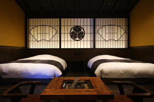 a room with two beds and a coffee table in the middle at Liberty Resort 久能宿 in Shizuoka