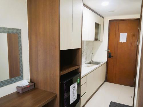a small kitchen with a sink and a microwave at Meisterstadt Pollux Habibie in Batam Center