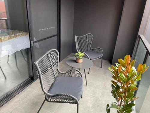 three chairs and a table on a balcony at CBD Elizabeth St Modern Townhouse - Secure Parking in Launceston