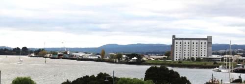 a large body of water next to a large building at Gateway to The Gorge, Central with Free Parking in Launceston