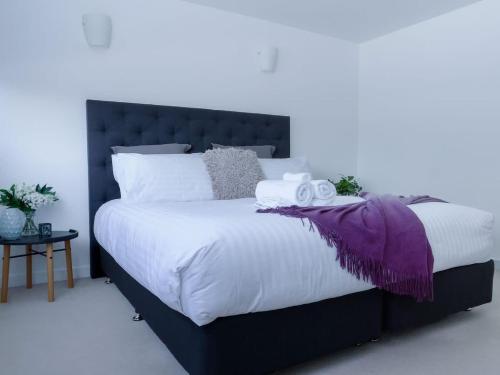 a bedroom with a large bed with a purple blanket at Gateway to The Gorge, Central with Free Parking in Launceston
