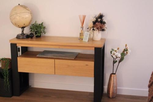 a wooden table with plants and a vase of flowers at Gateway to The Gorge, Central with Free Parking in Launceston