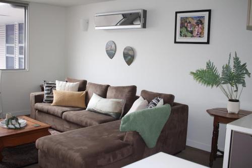 a living room with a brown couch and a table at Cataract 7 - CBD 2 Br Free Parking in Launceston