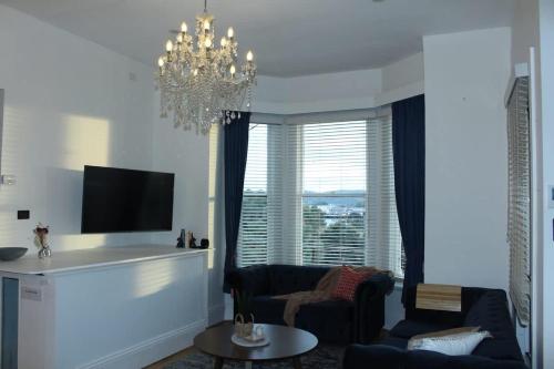 a living room with a couch and a chandelier at Forest Rd Haven with Tamar River Views in Inveresk