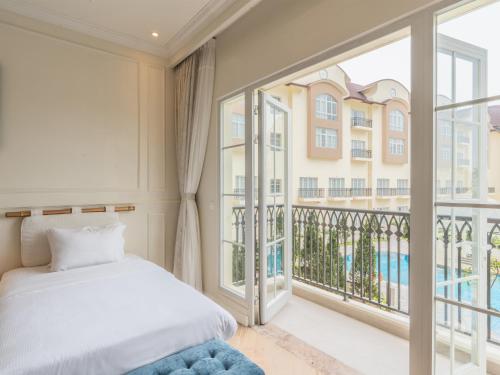 a bedroom with a bed and a balcony at Legend Valley Hotel Ha Nam in Phủ Lý