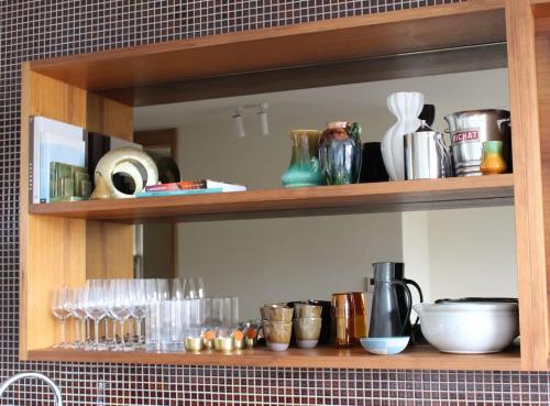 a shelf with glasses and other items on it at Le Salon Luxury City Apartment with Free Parking in Launceston