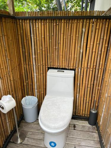 a toilet sitting in front of a wooden fence at Safari tent with private pool close to Manuel Antonio in Matapalo