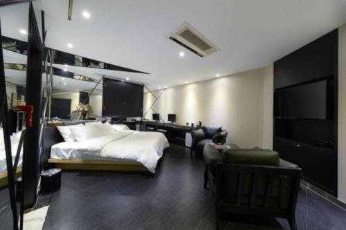 a bedroom with a bed and a desk and a couch at Life Style S Hotel in Seoul