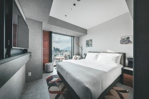 a bedroom with a large bed and a large window at SAPPORO STREAM HOTEL in Sapporo