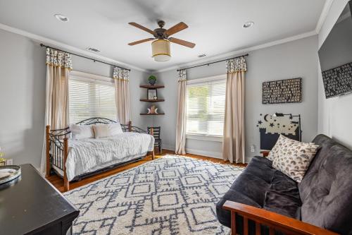 a bedroom with a bed and a couch and a fan at The Buford Manor in Buford