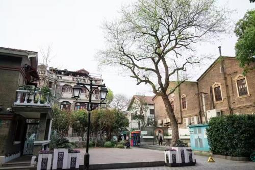 a city street with buildings and a tree at Weiting Hotel Shanghai North Sichuan Road Hongkou Football Stadium Subway Station Branch in Shanghai