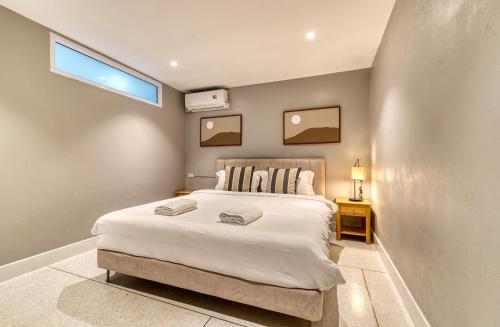 a bedroom with a large white bed and a window at AB House in Bangkok