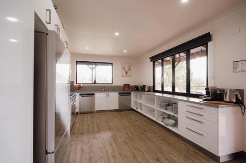 a kitchen with white cabinets and a large window at The Lodge - a destination in itself in Nulkaba