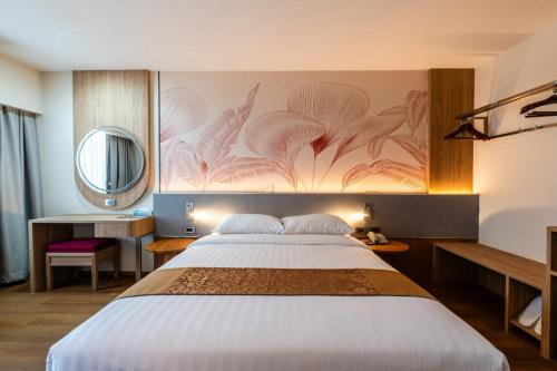 a bedroom with a large bed and a mirror at Asia Airport Hotel in Bangkok